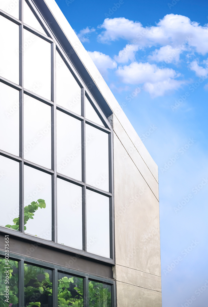 Geometric pattern of steel and glass wall on office building in loft style against blue sky background in vertical frame Geometric pattern of steel and glass wall on office building in loft style against blue sky background in vertical frame