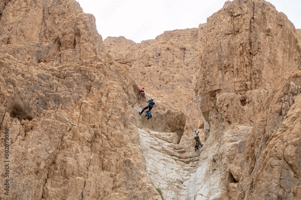 Experienced athletes start the descent with the equipment for snapping in the mountains of the Judean Desert near the Tamarim stream near Jerusalem in Israel