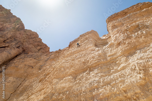 An experienced athlete athlete descends with the equipment for snapping in the mountains of the Judean Desert near the Tamarim stream near Jerusalem in Israel photo