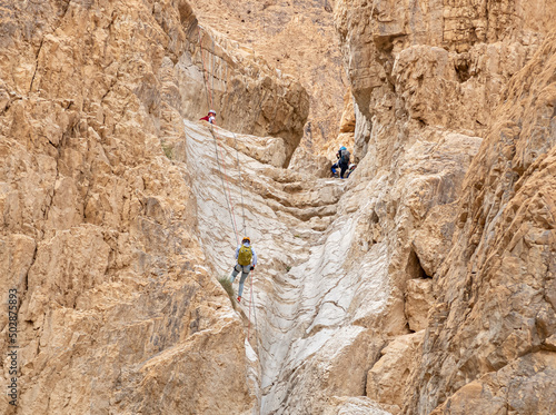 Experienced athletes start the descent with the equipment for snapping in the mountains of the Judean Desert near the Tamarim stream near Jerusalem in Israel
