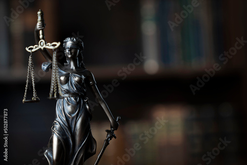 Judge office. Themis statue on the judge desk. Book shelf in the background. © zolnierek