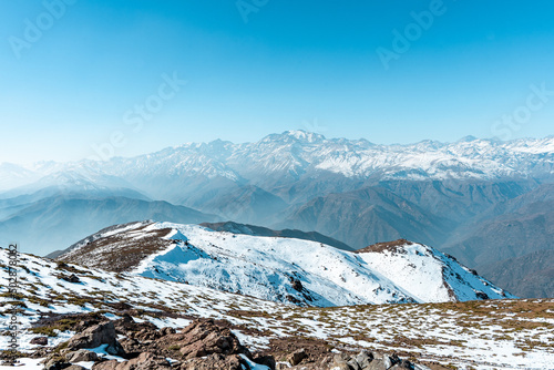 Horizontal view from snow-capped Provincia hill towards the snow-capped Andes mountain range, Chile.