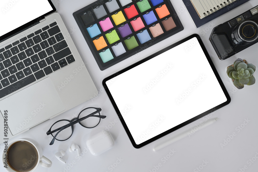 Creative designer workplace with digital tablet, laptop, camera and color swatch on white office desk. Creative designer workplace with digital tablet, laptop, camera and color swatch on white office desk.