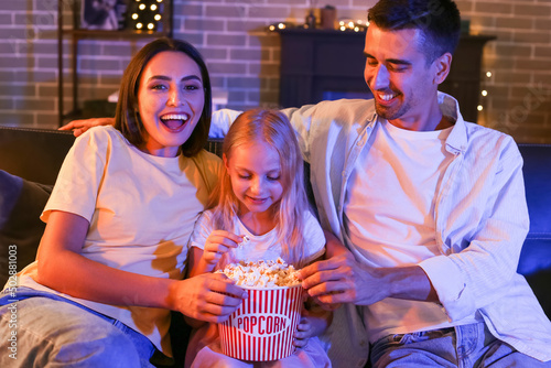 Happy family with popcorn w...