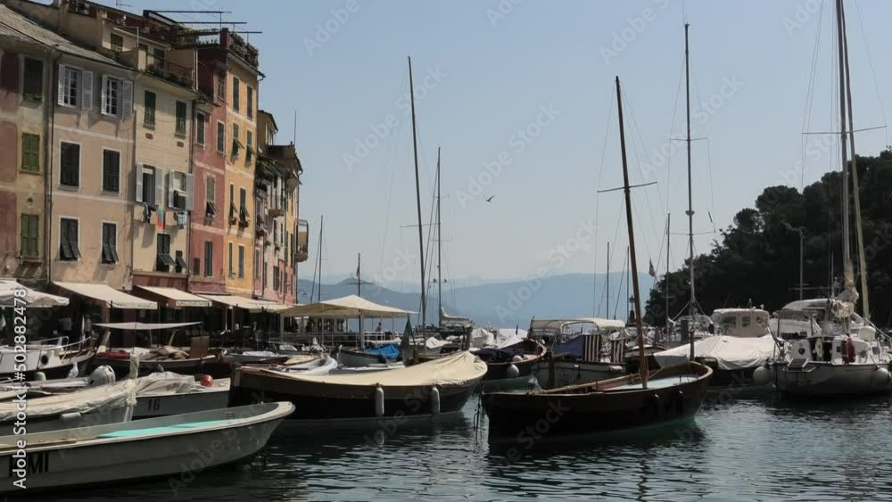 Close shot of quiet fishing village Portofino, Italy facing the open water in the summer with small boats in de harbour Close shot of quiet fishing village Portofino, Italy facing the open water in the summer with small boats in de harbour