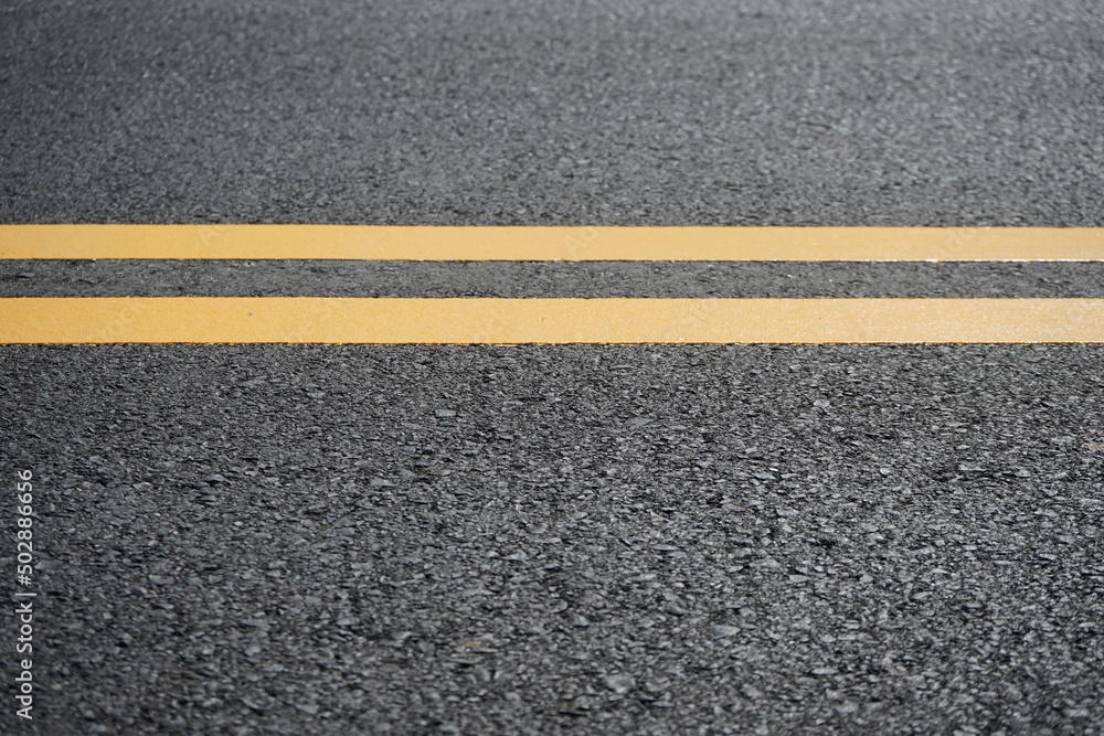 Fototapeta premium Blurred image of yellow traffic marking work on paved road