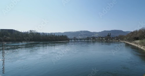 Les eaux calmes du Rhin entre Allemagne et Suisse. Bad Saeckingen. Pont couvert en bois (Alte Holzbrucke), Eglise St. Fridolin (Fridolinsmuenster) et la Tour Gallus sur rive droite du fleuve  photo