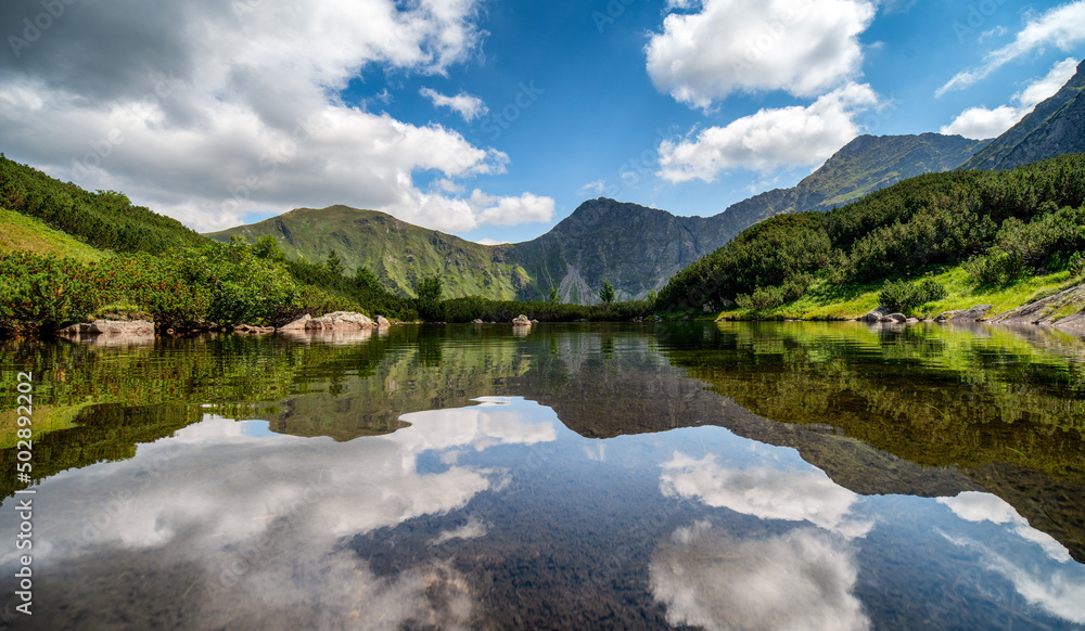 Reflection of hill and on water surface of mountain lake in Western tatras in Slovakia Reflection of hill and on water surface of mountain lake in Western tatras in Slovakia