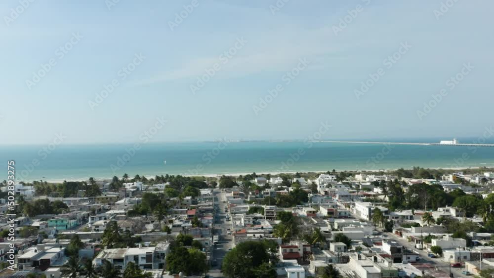 Tilt up aerial view over Puerto Progreso city in Yucatan peninsula, Mexico. Turquoise ocean water in the background Tilt up aerial view over Puerto Progreso city in Yucatan peninsula, Mexico. Turquoise ocean water in the background