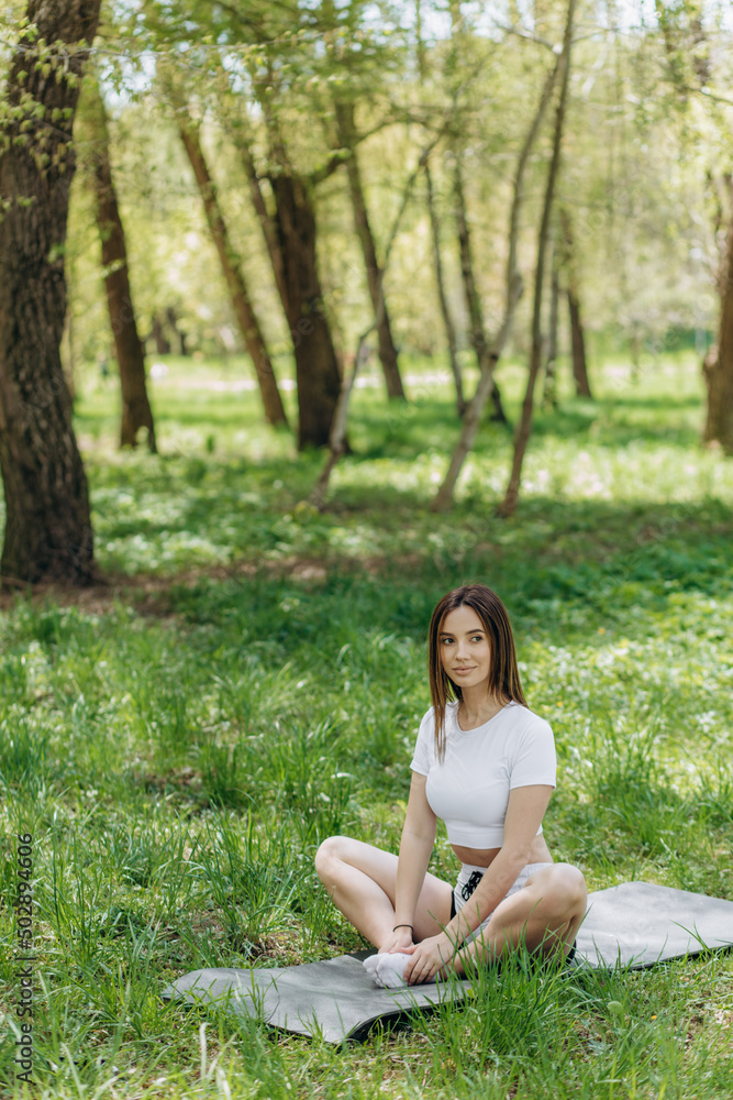 Young caucasian woman doing yoga exercises in summer city park. Young caucasian woman doing yoga exercises in summer city park.