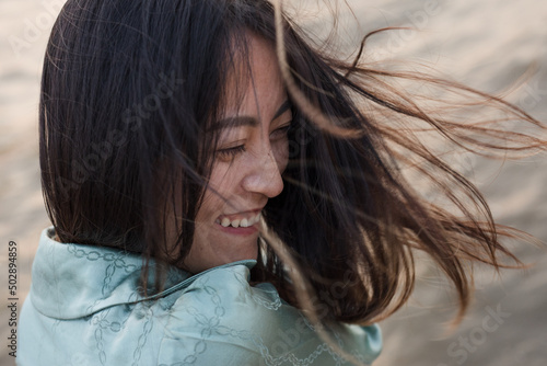 Beautiful Asian girl close up portrait with happy expression and blowing wind