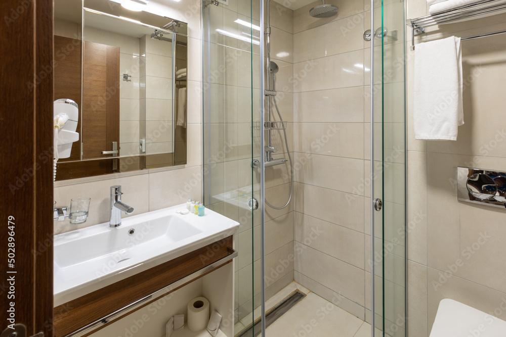 Interior of a hotel bathroom with glass shower cabin Interior of a hotel bathroom with glass shower cabin
