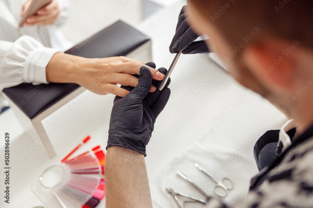 Shot of manicure process with nail file at salon Shot of manicure process with nail file at salon