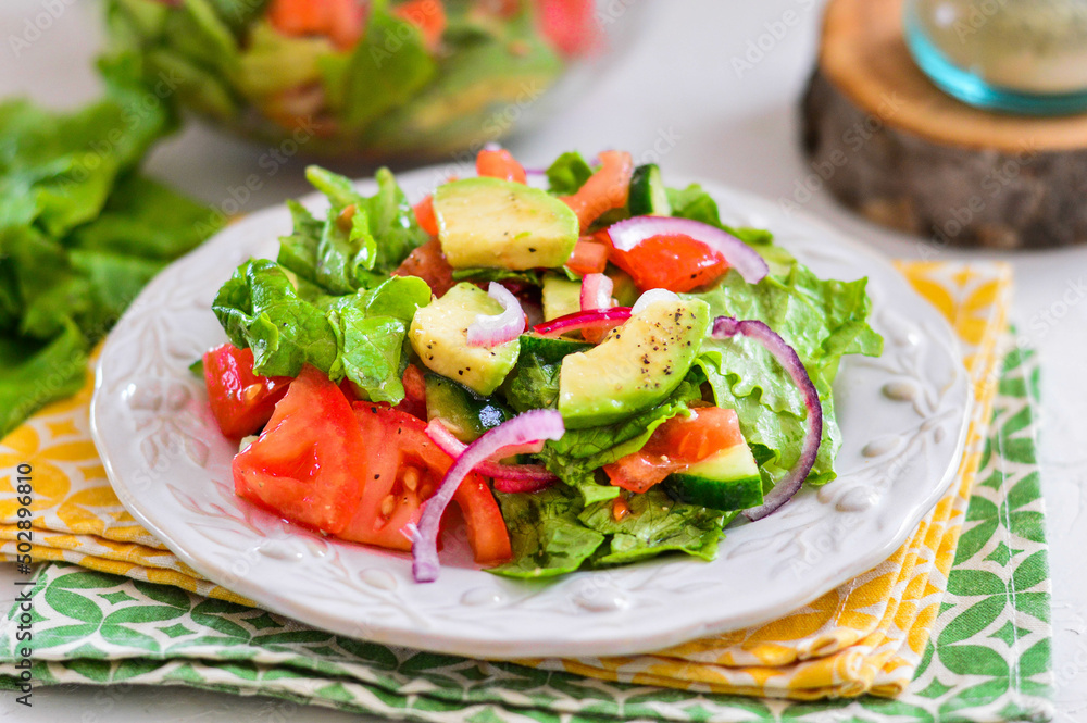 Salad of avocado, tomato, onion and lettuce. Light background. Salad of avocado, tomato, onion and lettuce. Light background.