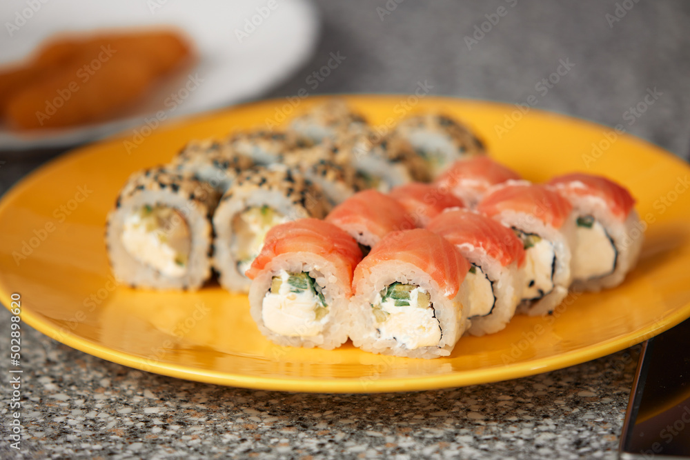 Traditional Japanese food, Asian cuisine with copy space. Yellow plate with rolls on table. Top view, close-up. Traditional Japanese food, Asian cuisine with copy space. Yellow plate with rolls on table. Top view, close-up.