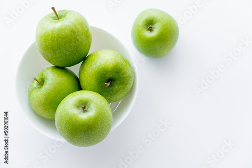 top view of ripe apples in bowl on white.