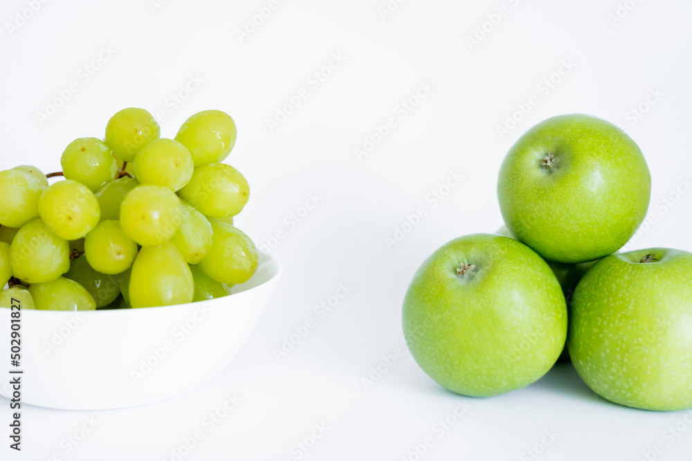 green grapes in bowl near apples on white. green grapes in bowl near apples on white.