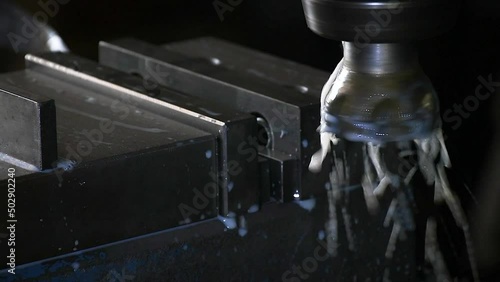 An employee is installing a workpiece on a CNC industrial metalworking cutting automation process by milling.Micro machining process , Coolant and lubrication.Close up of CNC machine at work.