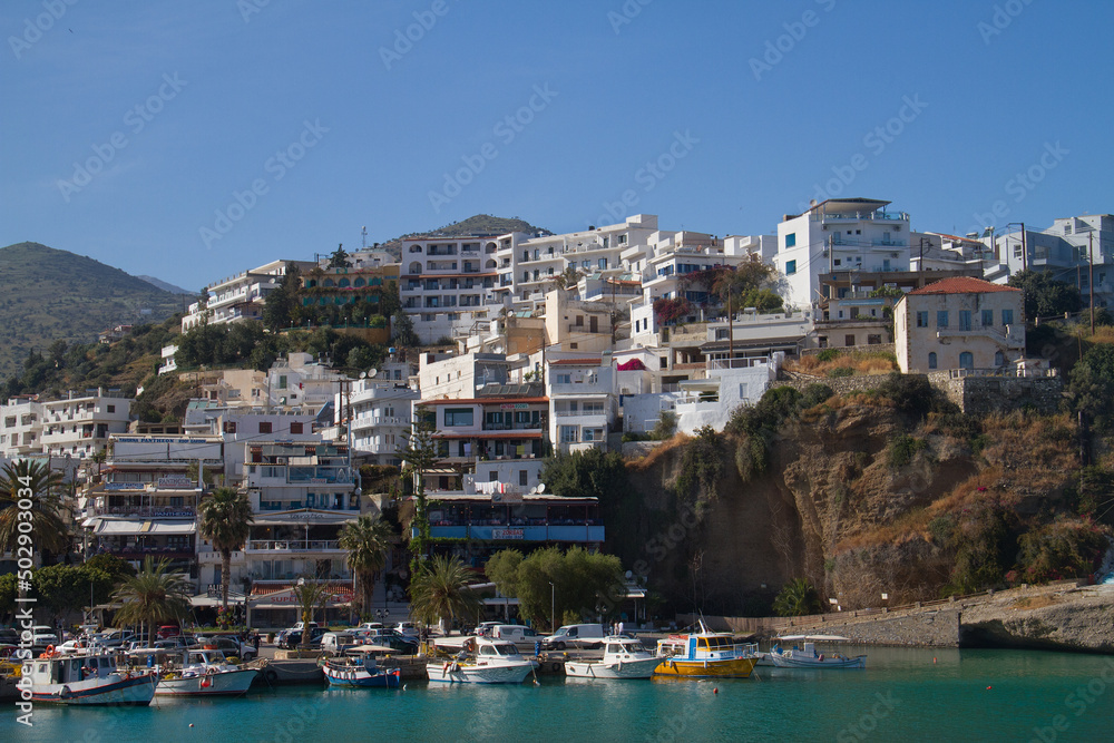 Agia Galini, picturesque mediterranean village with white houses and fishing boats in harbour with blue water 