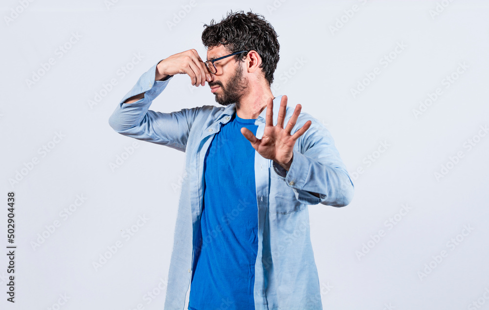 Confused unhappy man grabbing nose with fingers and stretching hand out feeling disgusted, A man with covering his nose Confused unhappy man grabbing nose with fingers and stretching hand out feeling disgusted, A man with covering his nose