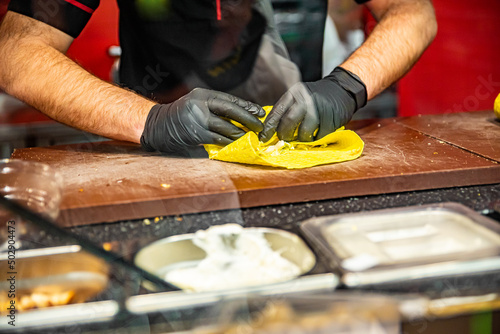 process of preparing traditional Turkish fast food - shawarma or kebab. chef hand cooking food