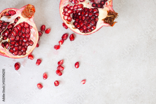 Obraz na plátně Pomegranate broken open with pips on a grunge surface with copy space