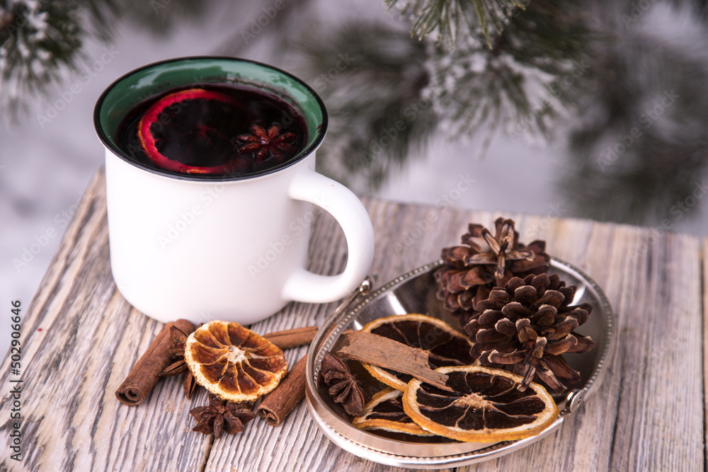 Close-up of mugs with mulled wine and spices on a wooden table in winter. Close-up of mugs with mulled wine and spices on a wooden table in winter.