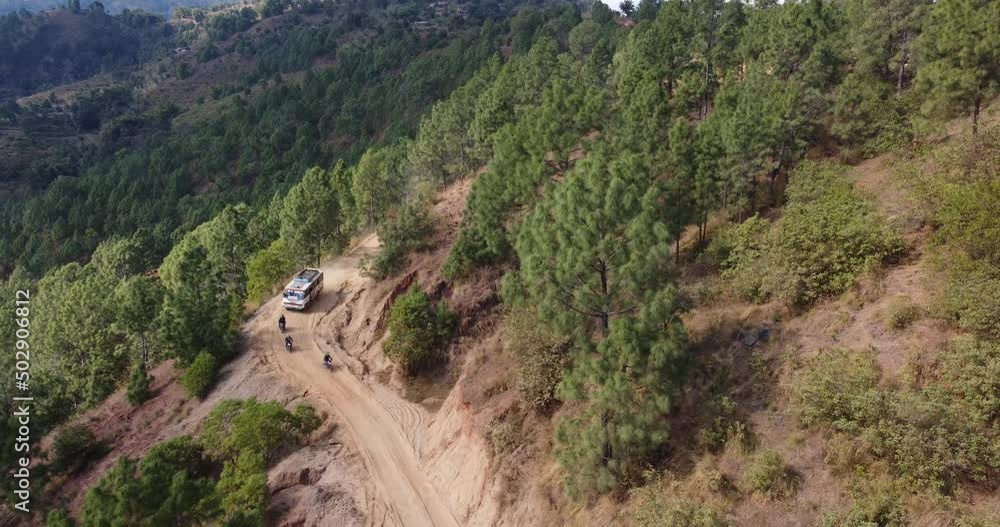 A Local Bus and Few Motorcycle is running in the dangerous off road of Nepal , Drone view of Bus ,Bikes and hill A Local Bus and Few Motorcycle is running in the dangerous off road of Nepal , Drone view of Bus ,Bikes and hill