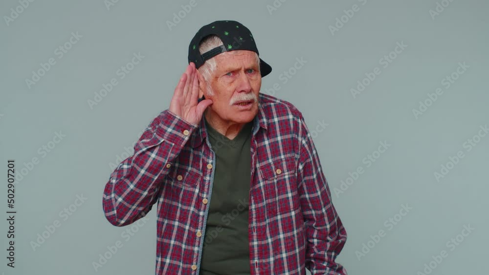 I cant hear you. What. Man trying hear you, looking confused and frowning, keeping arm near ear for louder voice, asking to repeat, to hear information, deafness. Senior grandfather on gray background I cant hear you. What. Man trying hear you, looking confused and frowning, keeping arm near ear for louder voice, asking to repeat, to hear information, deafness. Senior grandfather on gray background