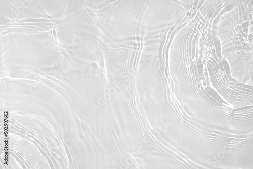 Desaturated transparent clear water surface texture with ripples, splashes Abstract nature background. White-grey water waves overlay Copy space, top view. Cosmetic moisturizer micellar toner emulsion © Aleksandra Konoplya