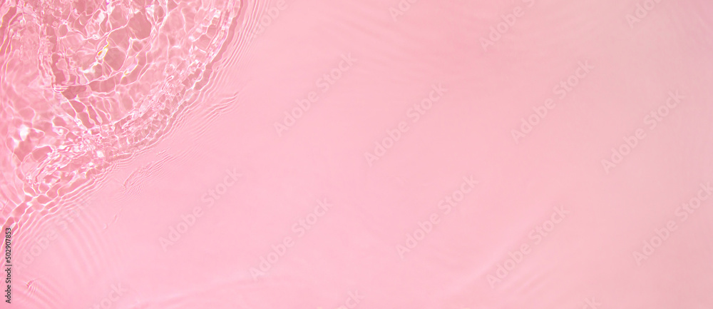 Abstract summer banner background Transparent pink clear water surface texture with ripples, splashes. Water wave in sunlight, copy space, top view. Cosmetics moisturizer micellar toner emulsion