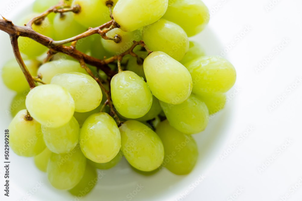 close up view of fresh grapes in bowl on white. close up view of fresh grapes in bowl on white.