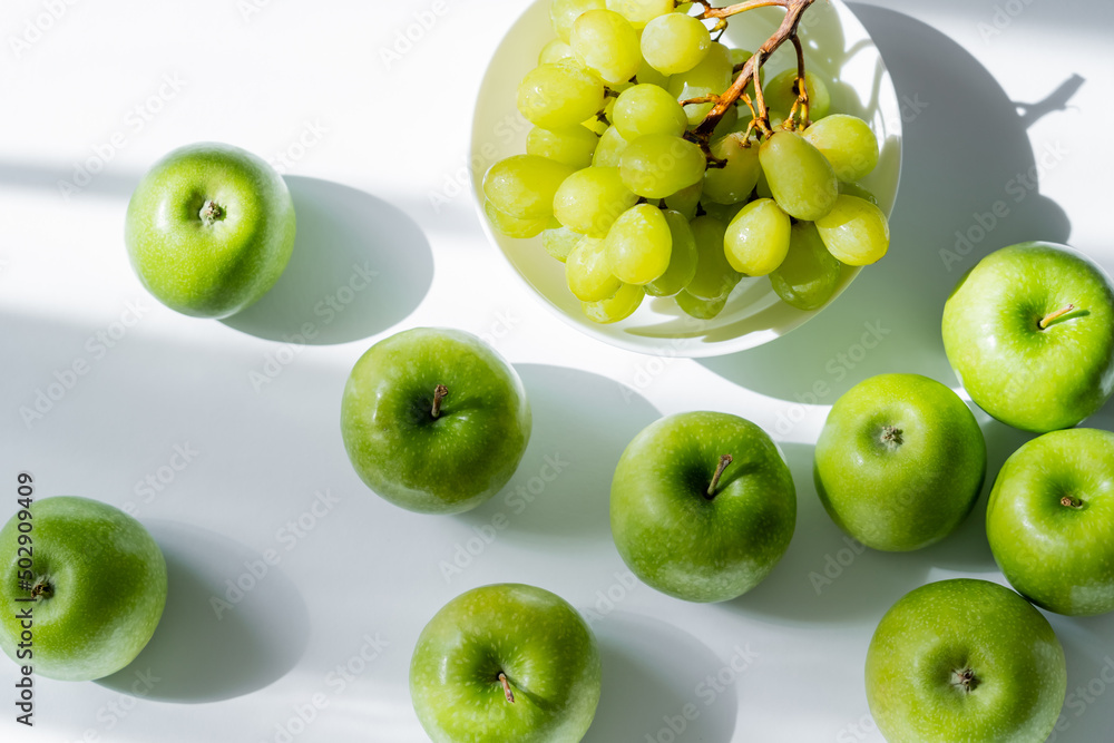 top view of bowl with sweet grapes and apples on white. top view of bowl with sweet grapes and apples on white.