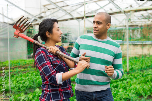 Two farm workers talking inside the greenhouse © JackF