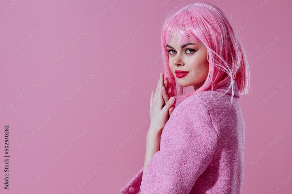 Beautiful fashionable girl pink jacket holding hair cosmetics pink background unaltered