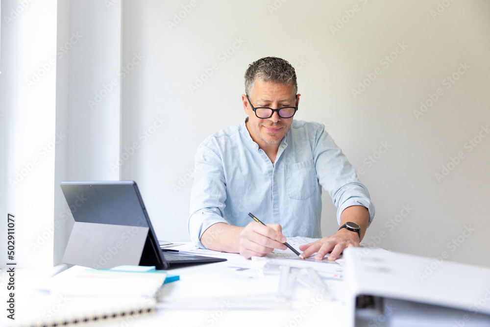 Business portrait of architect sitting at his work table and planning in his modern bright office Business portrait of architect sitting at his work table and planning in his modern bright office