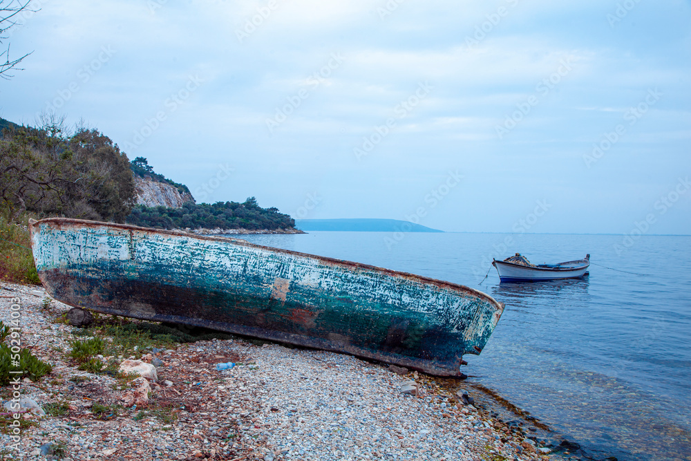 an old boat is looking at the new boat on the beach an old boat is looking at the new boat on the beach
