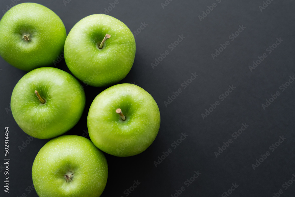 top view of whole and green apples on black. - obrazy, fototapety, plakaty 