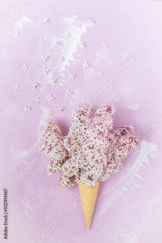 Waffle cone with pale pink lilac on a pink background