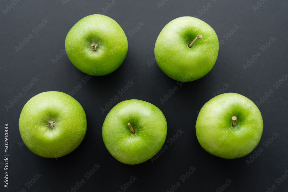 flat lay of fresh and green apples on black. - obrazy, fototapety, plakaty 