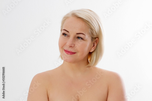 Beauty middle age woman face portrait. Spa and anti aging concept Isolated on white background. Plastic surgery and collagen face injections. Wrinkles and menopause. Mock up. Copy space