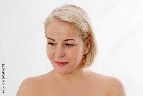 Beauty middle age woman face portrait. Spa and anti aging concept Isolated on white background. Plastic surgery and collagen face injections. Wrinkles and menopause. Mock up. Copy space