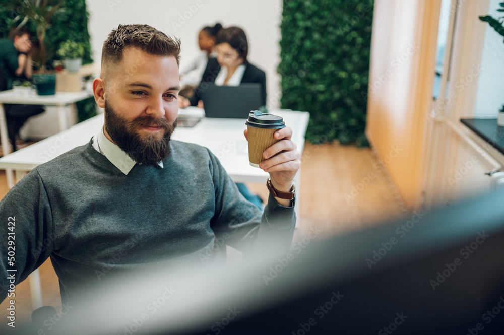 Handsome businessman sitting at his desk in the office Handsome businessman sitting at his desk in the office