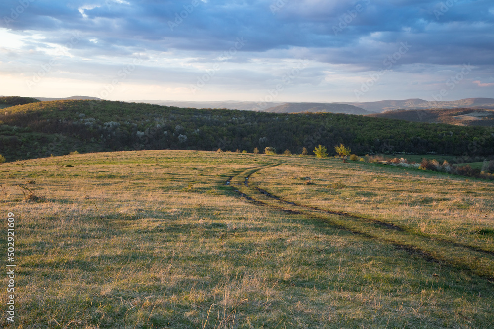 amazing sunset sky over green hills in early summer