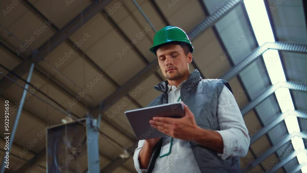 Livestock worker holding tablet computer in shed. Dairy production professional Livestock worker holding tablet computer in shed. Dairy production professional