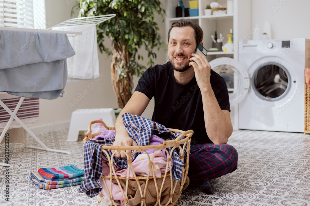 Portrait of smiling man sitting on the bathroom floor, laundry room