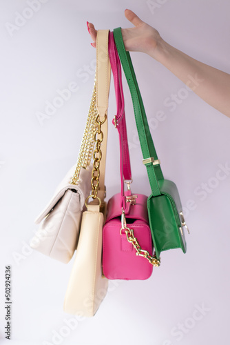 woman hand holding set of colorful bags. Product composition photography. handbag and purse for women