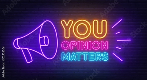 Your opinion matters with a megaphone neon sign on brick wall background.