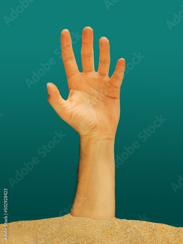 Creepy man hand coming out of the sand ground. Spooky cocept.