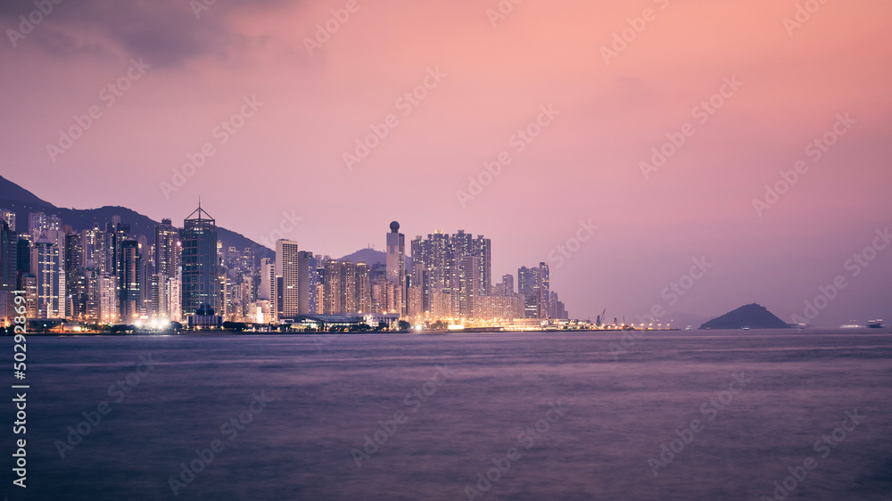 Fototapeta premium Urban skyline with illuminated skyscrapers at dusk. Hong Kong cityscape..